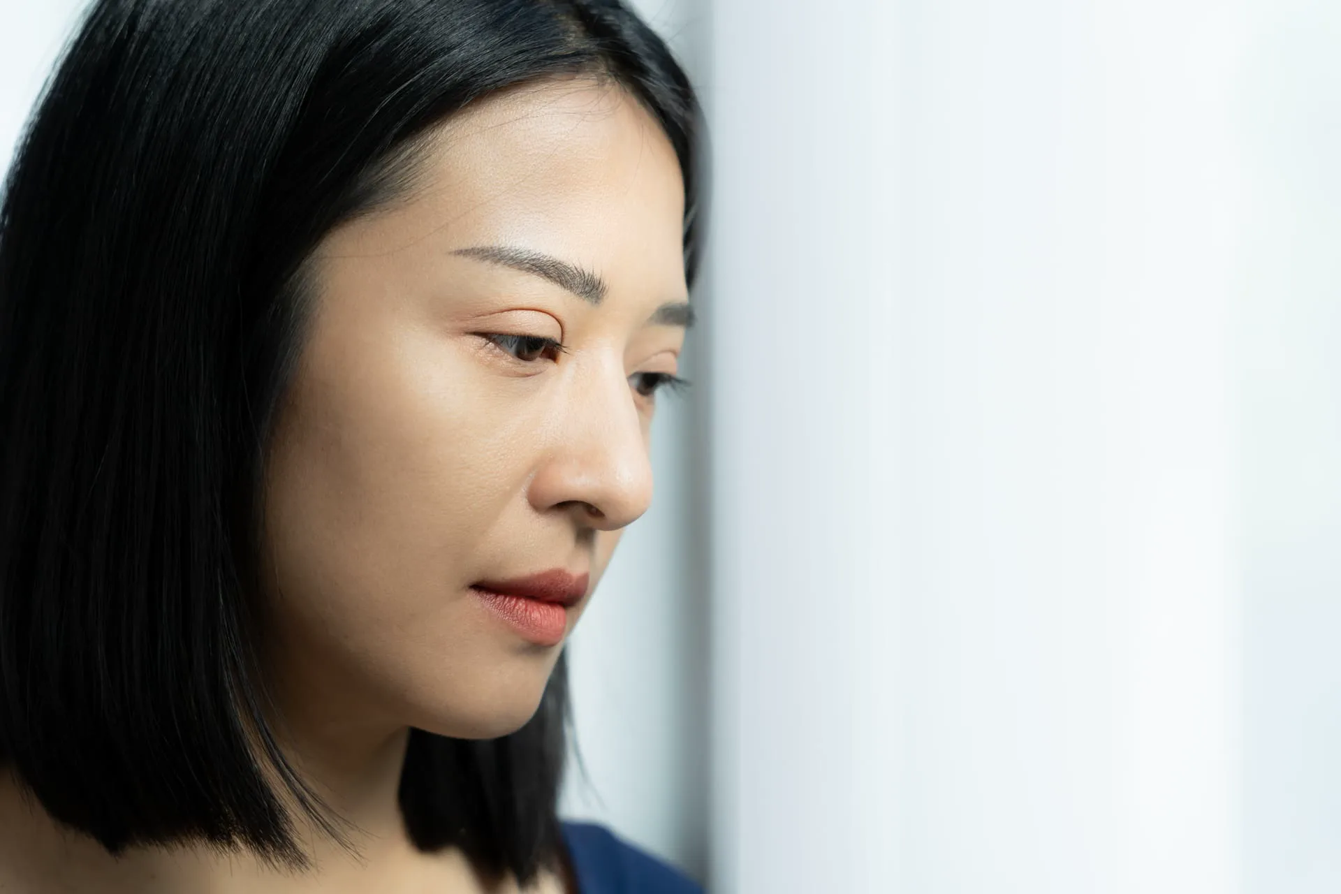 Woman sitting in profile with her hand resting near her face